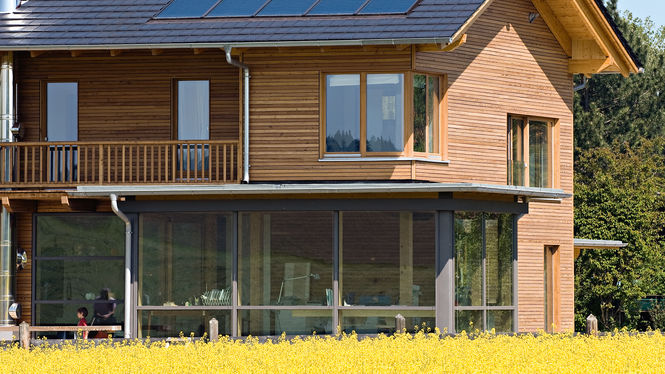 Holzhaus mit Solaranlage am Feldrand