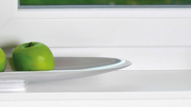 Teller mit grünen Äpfeln am Fenstersims